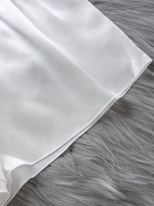 Detailansicht des weißen Seidensatin-Schlafanzugs mit hochwertigen Nähten und glattem Stoff
