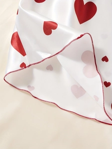 Dettaglio di camicia da notte in raso bianco con cuori rossi e cucitura dell'orlo