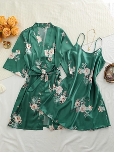 Flat lay of silk-like satin sleepwear set with floral patterns and luxury accessories