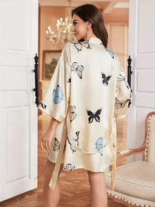 Detailed texture of cream satin robe featuring elegant blue butterfly patterns and matching belt