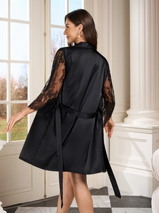 Close-up of black satin robe featuring elegant lace sleeves and a silky tie belt