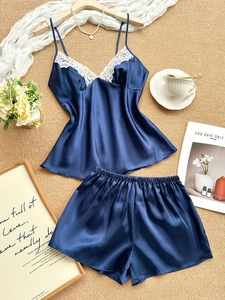Detailed flat lay of navy blue satin pajamas with delicate white lace trim and V-neckline