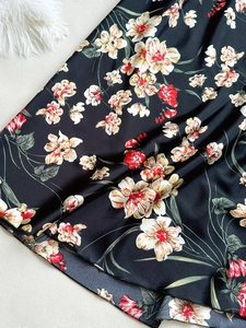 Detailansicht des Blumenmusters auf dem schwarzen seidenartigen Satin-Nachthemd