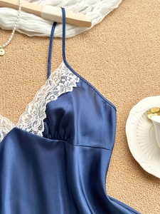 Detail of silk v-neck pajama top with delicate white lace trim and satin texture