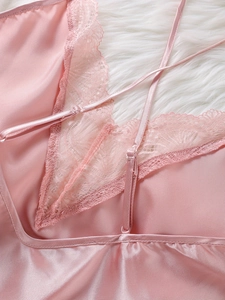 Detail of pink satin camisole with delicate eyelash lace trim and adjustable straps