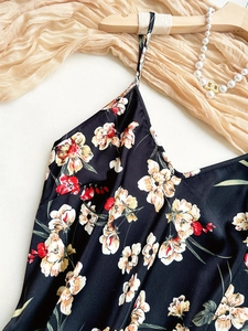 Detailaufnahme des schwarzen Satin-Top mit Blumenmuster und feinen Trägern
