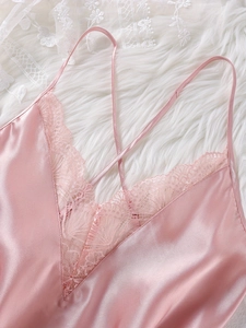 Close-up of pink satin pajama top featuring delicate eyelash lace trim and V-neckline