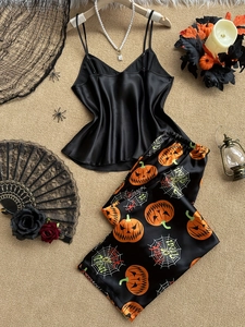 Dettaglio del pigiama satinato di Halloween con stampe di zucche e ragnatele