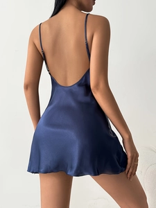 Detail of navy blue satin sleepwear showing open back design and silky texture