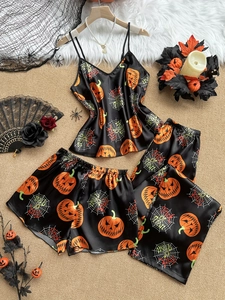 Detail of Halloween satin pajama set featuring pumpkin and spider web prints on black fabric