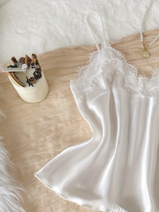 Gros plan détaillé du caraco en satin blanc avec garniture en dentelle de cils délicate