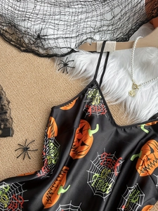 Detail of Halloween satin sleepwear featuring pumpkin and spider web prints on black fabric