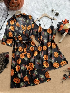 Detail view of smooth ice silk fabric with orange pumpkin and spider web Halloween prints