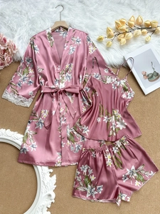 Détail d'un ensemble de pyjama en satin rose fleuri avec élégante bordure en dentelle blanche