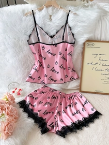 Détail d'un ensemble pyjama en satin rose avec imprimé love et bordure en dentelle