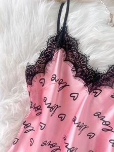 Détail de pyjama en satin rose avec dentelle de cils noire et motif de cœurs love