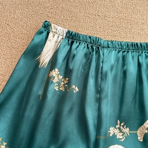 Green silk pajama pants with white floral and crane prints in Chinese style