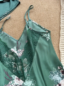 Dettaglio camicia da notte in raso verde scuro con stampa floreale e pizzo sullo scollo