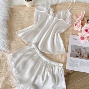 Ensemble pyjama en soie blanche avec camisole en dentelle et short sur fond floral