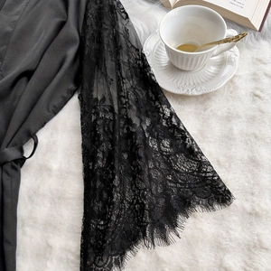 Elegante vestaglia in seta nera con polsini in pizzo e dettaglio con bordo a ciglia