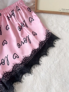 Détails du short de nuit en satin rose avec motifs cœurs noirs et dentelle fine