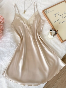 Détail de la chemise de nuit en satin champagne avec dentelle blanche et col en V profond