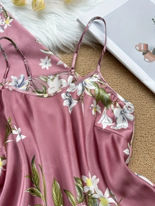 Détail d'une nuisette en satin rose avec motif élégant de fleurs blanches