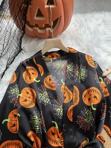 Detail of ice silk Halloween robe with pumpkin prints and Trick or Treat spider web pattern