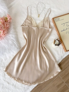 Détail de la chemise de nuit en satin champagne avec dentelle délicate et texture soie