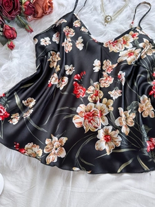 Dettaglio della canotta in raso nero con stampa floreale, rose e perle decorative