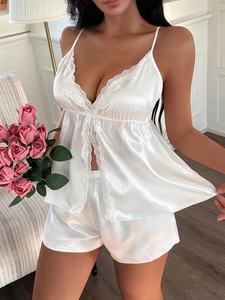 Détail de l'ensemble de pyjama en satin blanc avec dentelle délicate sur le caraco