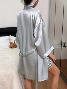 Détail du peignoir en satin bleu clair avec ceinture à nouer et bandeau assorti
