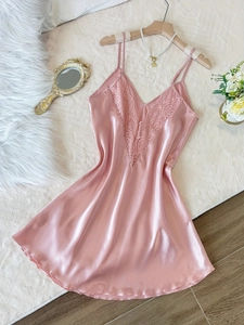 Vue détaillée d'une nuisette en satin rose avec dentelle sur surface veloutée