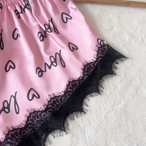 Ensemble de pyjama en satin rose avec motifs cœurs et bordure en dentelle noire