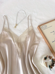 Détail de la nuisette en satin champagne avec bordure en dentelle blanche et col en V