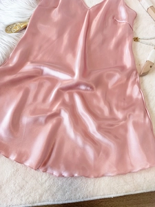 Détail à plat d'une nuisette en satin rose avec col en V et drapé élégant de luxe