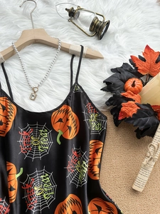 Detail of Halloween satin camisole with pumpkin and spider web prints on plush rug