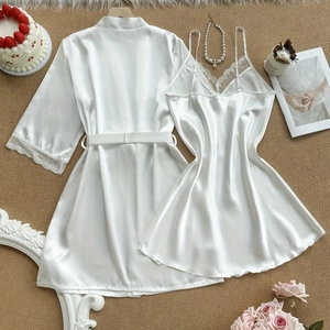 Weißes Satin-Pyjama-Set mit Spitze und Bindegürtel auf einem dekorativen Teppich