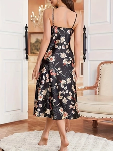 Nahaufnahme eines schwarzen Satin-Slipkleides mit eleganten weiß-rosa Blumenmustern