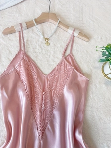 Détail d'une nuisette rose en soie avec dentelle raffinée et décolleté en V élégant