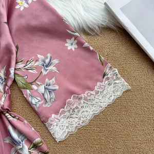 Peignoir floral en satin rose avec poignets en dentelle blanche et détails soyeux