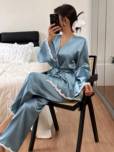Close-up of white lace trim on blue satin silk pajama top cuffs and hem detailing