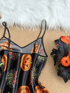 Detail view of Halloween satin sleepwear featuring orange pumpkin and spider web prints