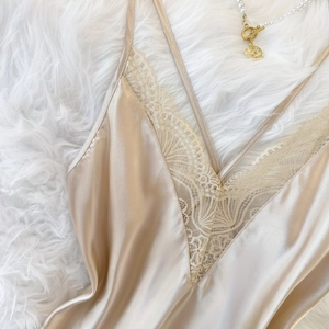 Champagnergoldenes Satin-Top mit V-Ausschnitt und Spitze auf Plüsch-Hintergrund