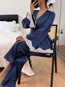 Detail of dark blue satin robe with white lace trim on cuffs and delicate silk texture