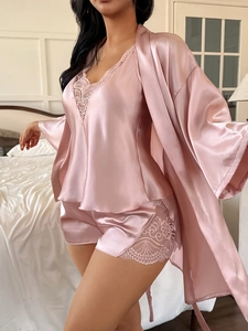 Close-up of elegant pink satin sleepwear set featuring fine lace trim and silky texture