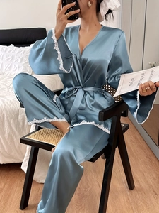 Detail of blue satin robe with delicate white floral lace on cuffs and hem