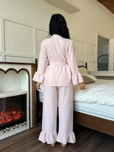 Rear view of pink pajama set featuring ruffled hems and soft seersucker fabric texture