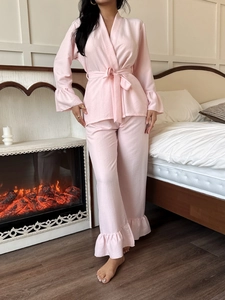 Detail of light pink pajama set featuring ruffled cuffs and soft crepe texture fabric