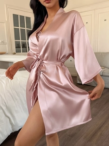 Detailed macro view of pink satin silk bathrobe fabric with delicate lace trim details